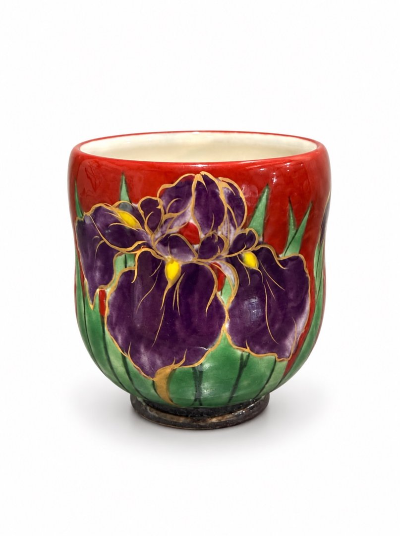 A red teacup painted with irises