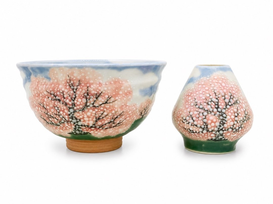A matcha bowl and chasen rest painted with cherry blossoms